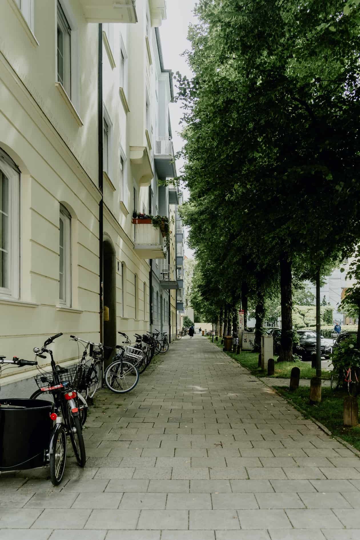 Gepflasterter Gehweg vor einem Wohn- und Gewerbegebäude